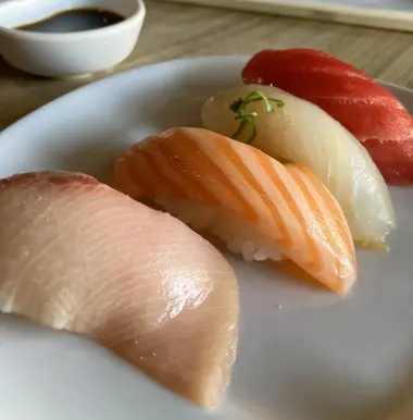 assorted sushi with soy sauce in background