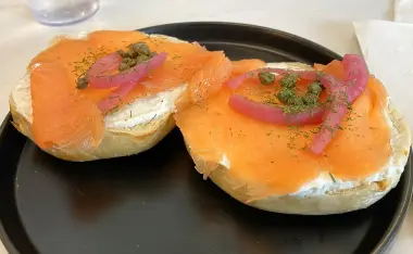 two bagel halves with smoked salmon, cream cheese, onions, capers, and dill